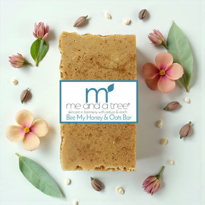 Bar of soap with 'me and a tree' branding surrounded by flowers and leaves on a white background