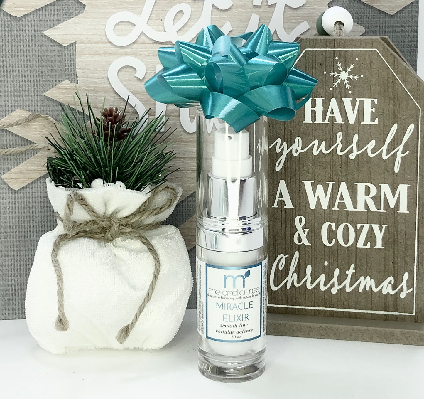 one carrot and tamanu facial serum with teal bow in holiday cozy setting